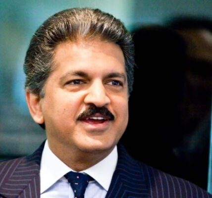 Anand Mahindra, a distinguished figure in a business suit, exudes confidence and leadership.