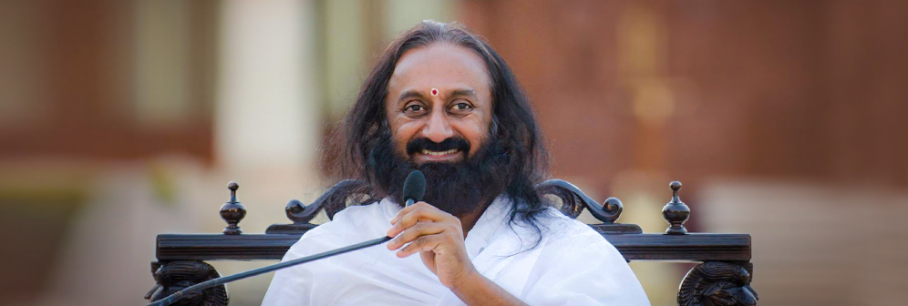 Sri Sri Ravi Shankar smiling during a public event, representing peace and spiritual leadership.