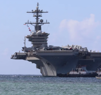 Harbour tugboats escort the Nimitz-class aircraft carrier USS Abraham Lincoln as it arrives at the US Naval Base in Guam for a scheduled port visit.